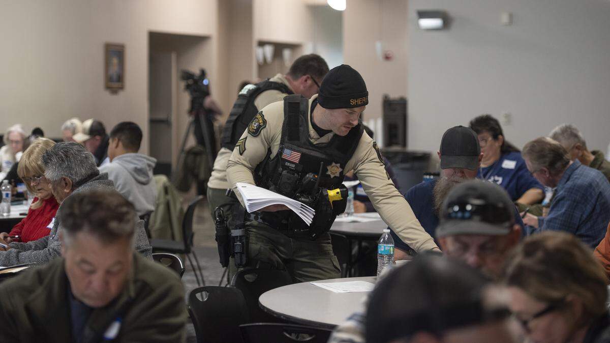 A Stanislaus County Sheriff’s Office deputy hands out materials during a faith-based security workshop attended by hundreds of faith leaders and volunteers in Modesto. The training focused on emergency preparedness, medical response and safety planning for places of worship.