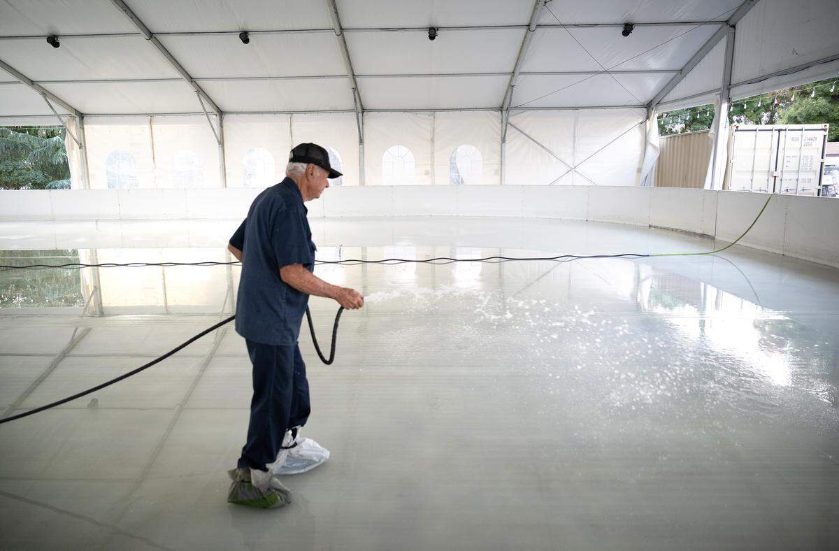 Bob Watts adds water to the ice rink as Modesto on Ice prepares to open in Modesto on  Monday, Nov. 17, 2025. The seasonal ice rink opens Nov. 22.
