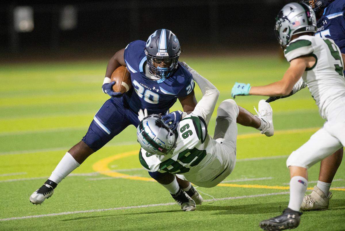 Downey’s Ki Ragland is taken down by Pitman’s Alex Rodriguez during the Central California Athletic League game at Downey High School in Modesto, Calif., Friday, Oct. 28, 2022.