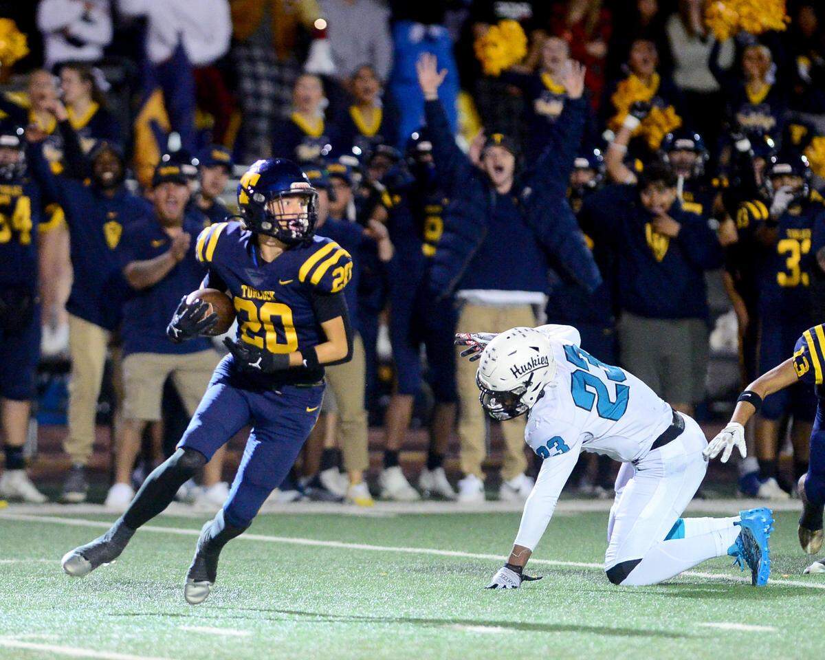 Turlock’s Bradlee Green (20) runs after intercepting a pass during a CIF Sac-Joaquin Section Football Division I playoff game between Turlock High School and Sheldon High School at Turlock High School in Turlock, California on Nov. 3, 2023.
