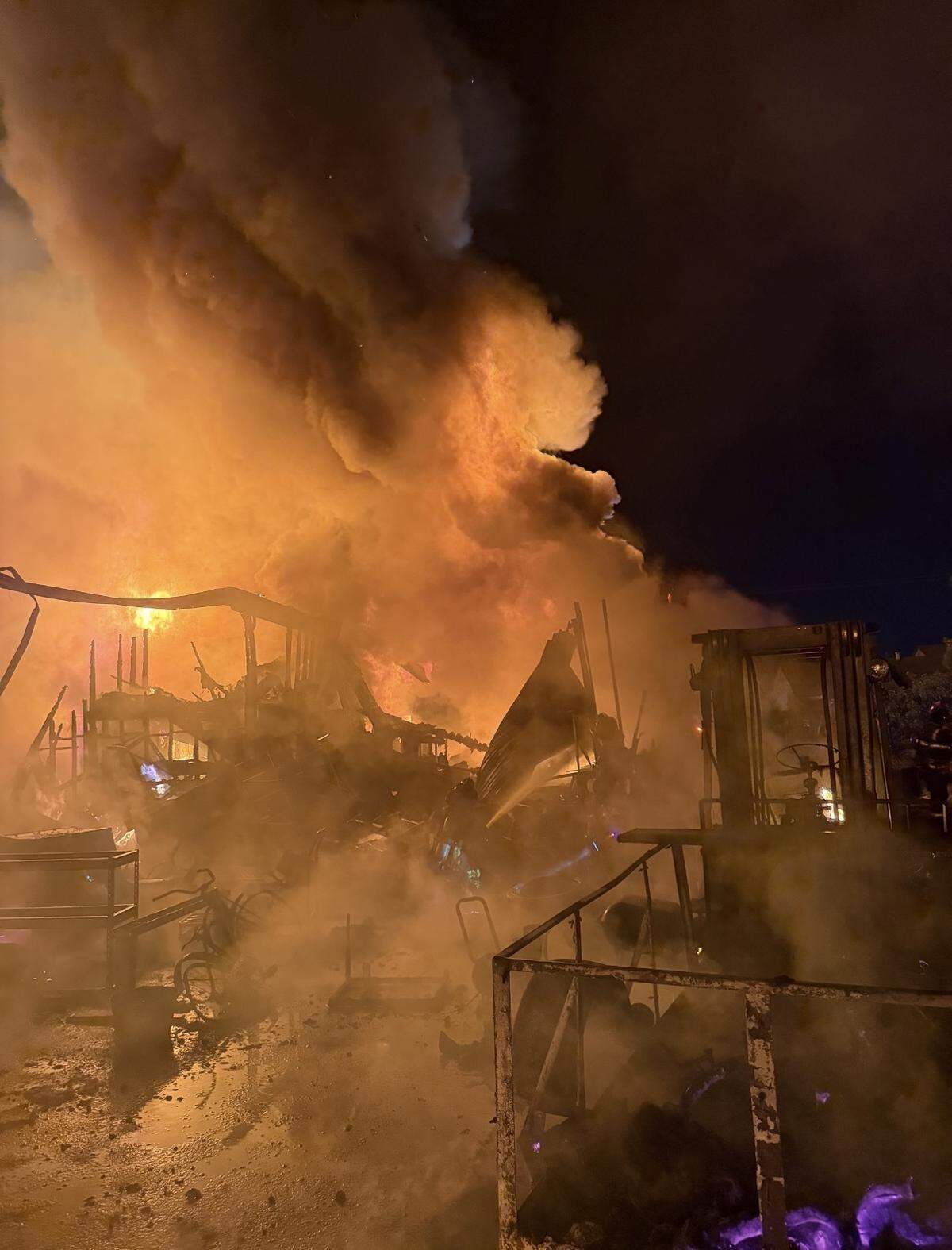 Flames tear through debris and equipment, including a forklift, as crews work to contain a structure fire on Beard Avenue in Modesto.