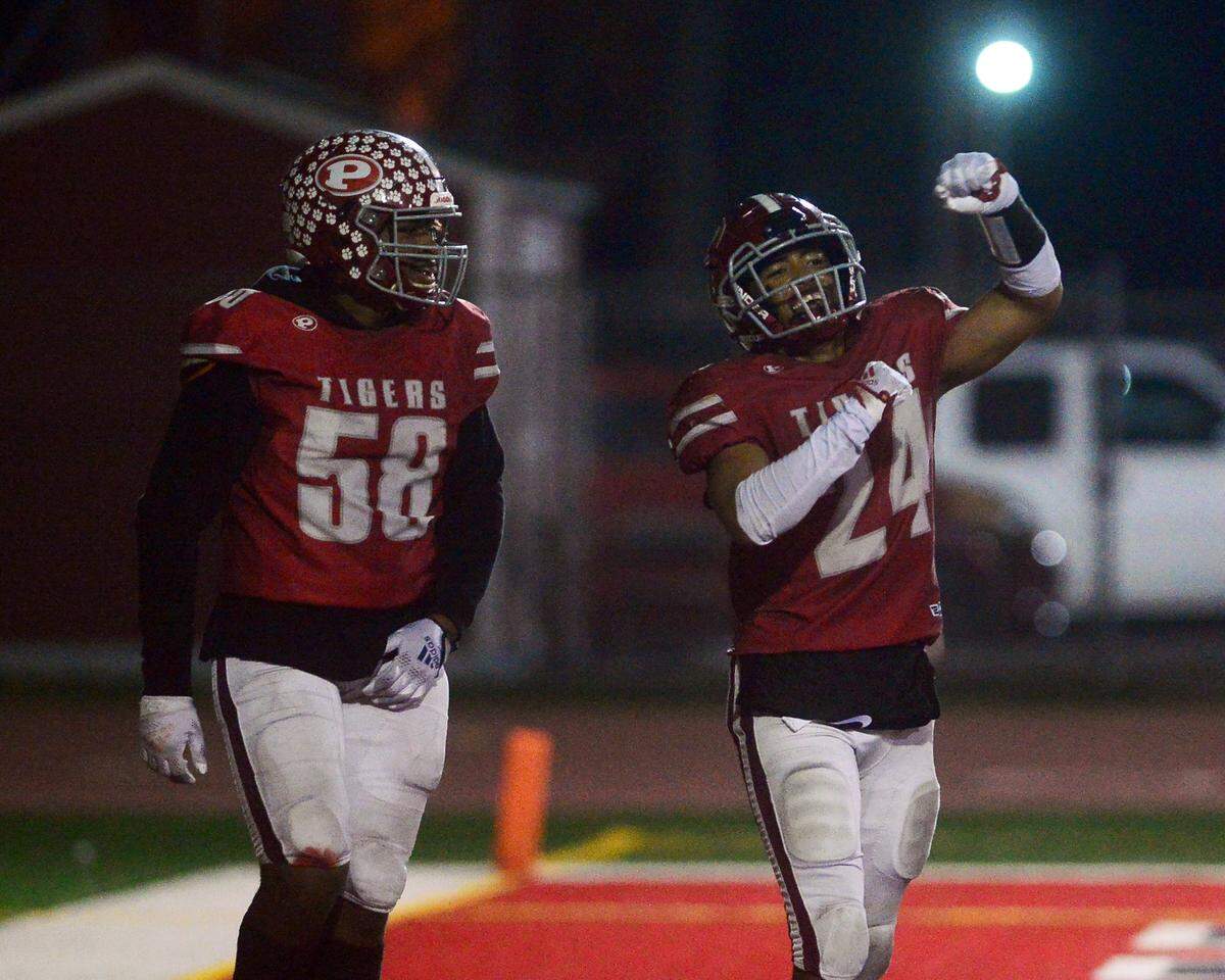 Patterson’s Lolo Mataele (24) celebrates with teammate Quincey Simien after scoring a touchdown during a CIF Division III Sac-Joaquin Section football playoff game against Roseville at Patterson High School in Patterson, California, on Nov. 11, 2022. Patterson won 56-34.