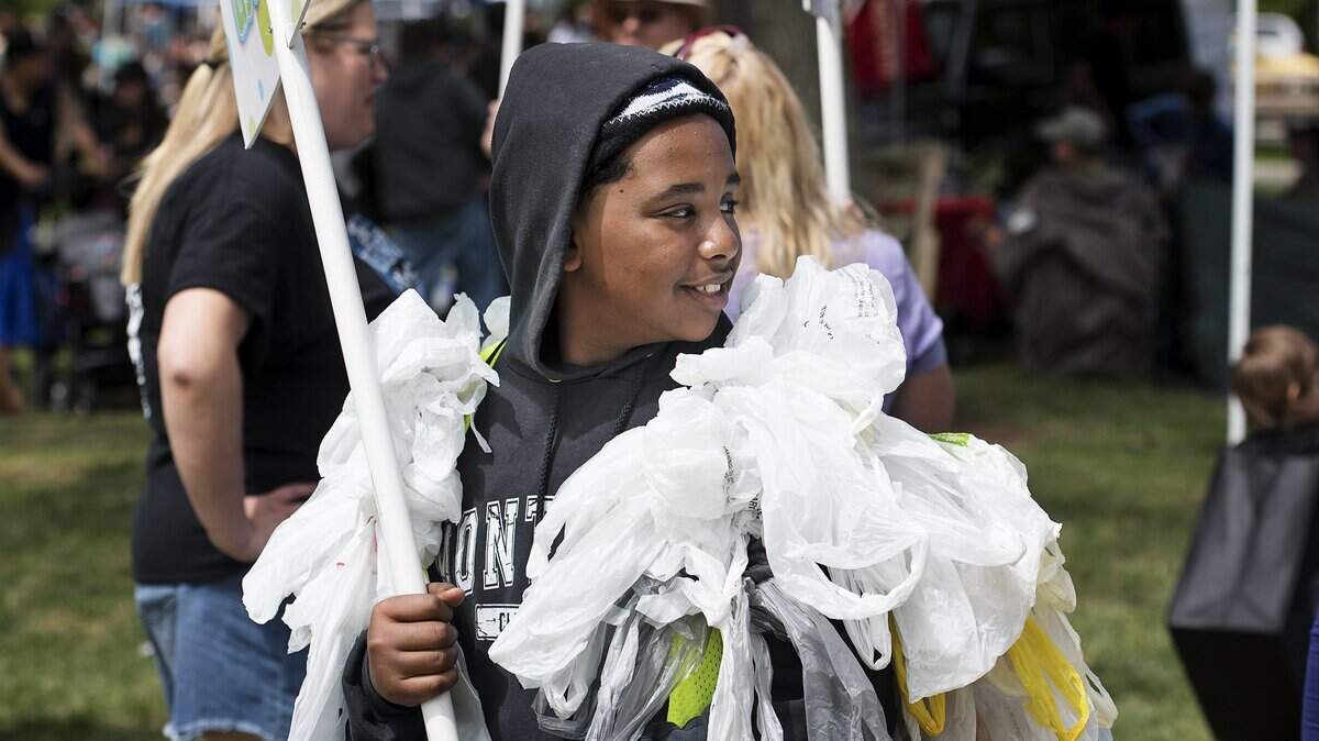 Omar Mustafa wears a vest made with single use plastic bags to promote the use of reusable grocery bags during 2017 Earth Day festivities at Graceada Park.