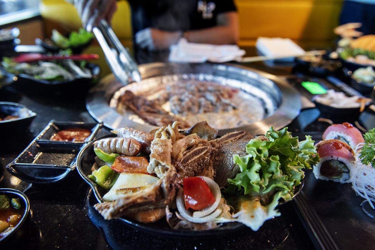 Co-Owner Annie Chang grills meat and vegetables on the table grill at Hoki Korean BBQ & Japanese Cuisine on Coffee Road in Modesto, Calif., Wednesday, Oct. 23, 2019.