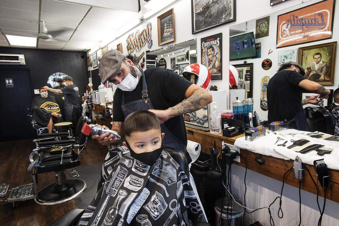 Barber Dustin Escarcega cuts the hair of Francisco Munoz, 2, at Trevino’s Barbershop in Modesto, Calif., on Thursday, May 28, 2020.