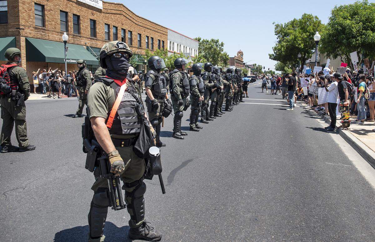 Stanislaus County Sheriff’s deputies make a line between protesters and counter-protesters during a demonstration in support of George Floyd in Oakdale, Calif., on Wednesday, June 3, 2020. Several hundred people gathered in downtown Oakdale for a demonstration in response to the death of a black man in police custody in Minnesota last week.