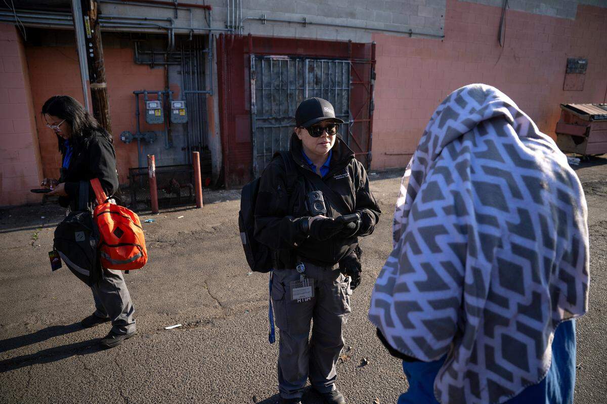 CHAT(Community Health and Assistance Team) outreach specialists Christina Kenney, right, and Christina Hernandez, left, talk with unhoused people during the county’s Point in Time homeless count in Modesto on Thursday, Jan. 30, 2025.