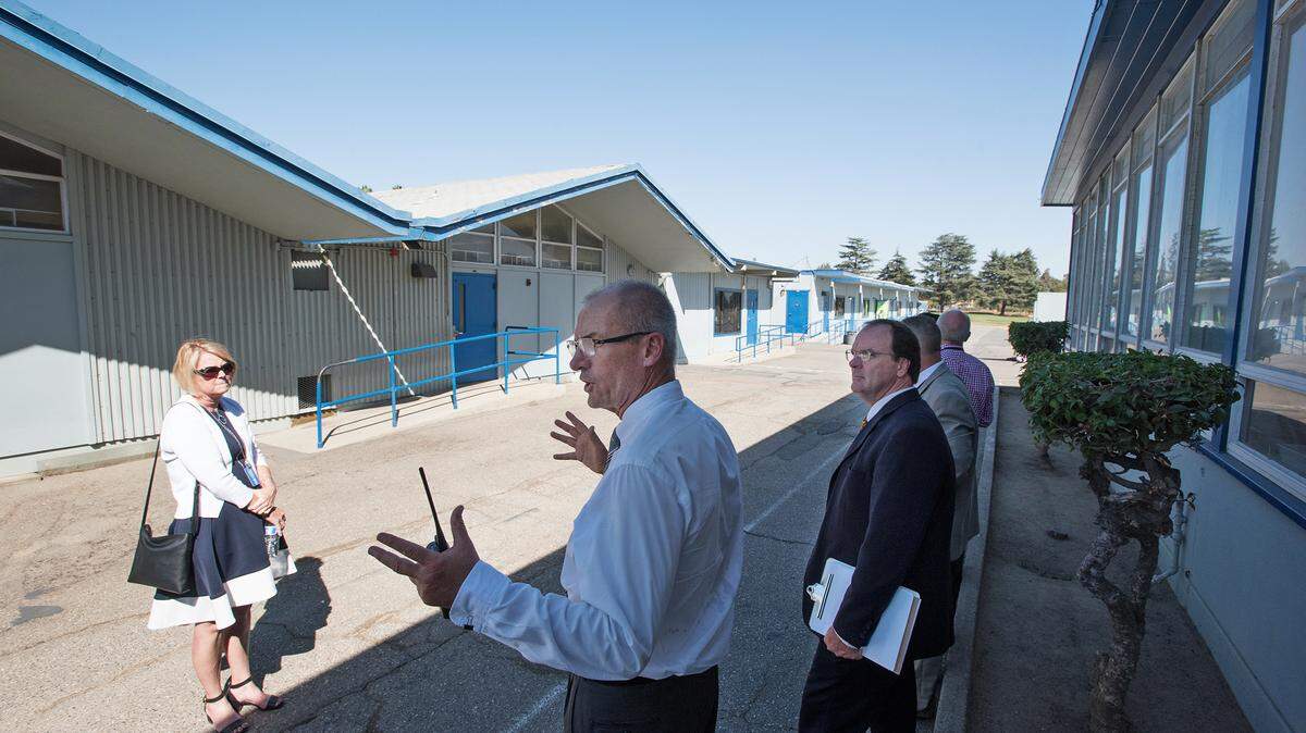 Principal Scott Genzmer, middle, shows facilities and district guests the 50’s era classrooms and portables at Franklin Elementary School in Modesto, Calif., on Tuesday, Sept. 25, 2018. Modesto City Schools has two bond measures on the November ballot to generate funds for renovating elementary school facilities.