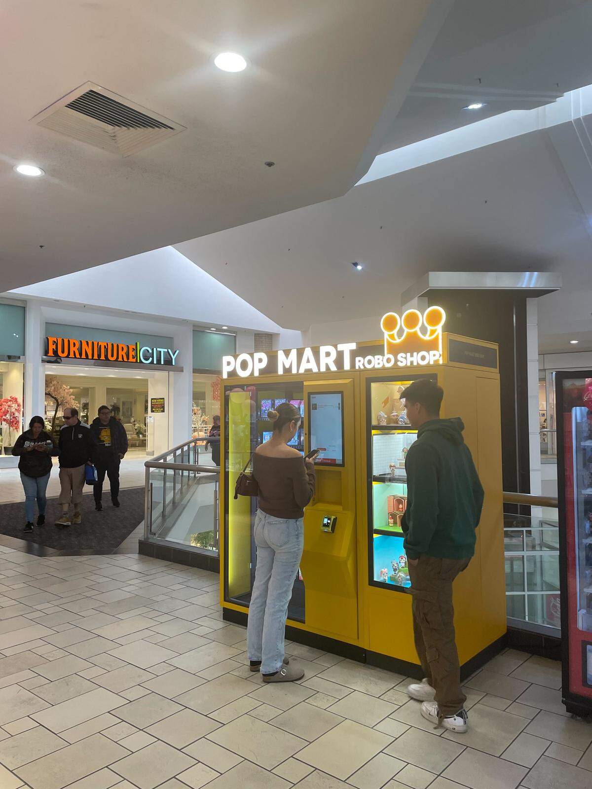 Shoppers check out the  Pop Mart Robo Shop vending machine at Vintage Faire Mall on Oct. 14.