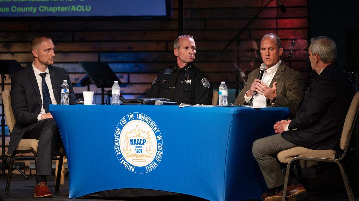 Panelists, FBI Special Agent Christopher McKinney, left, Modesto Police Chief Brandon Gillespie and moderator Garth Stapley, right, listen to Stanislaus County Sheriff Jeff Dirkse during a town hall meeting on domestic terrorism at the Redeemer Modesto church in Modesto, Calif., on Thursday, March 24, 2022.