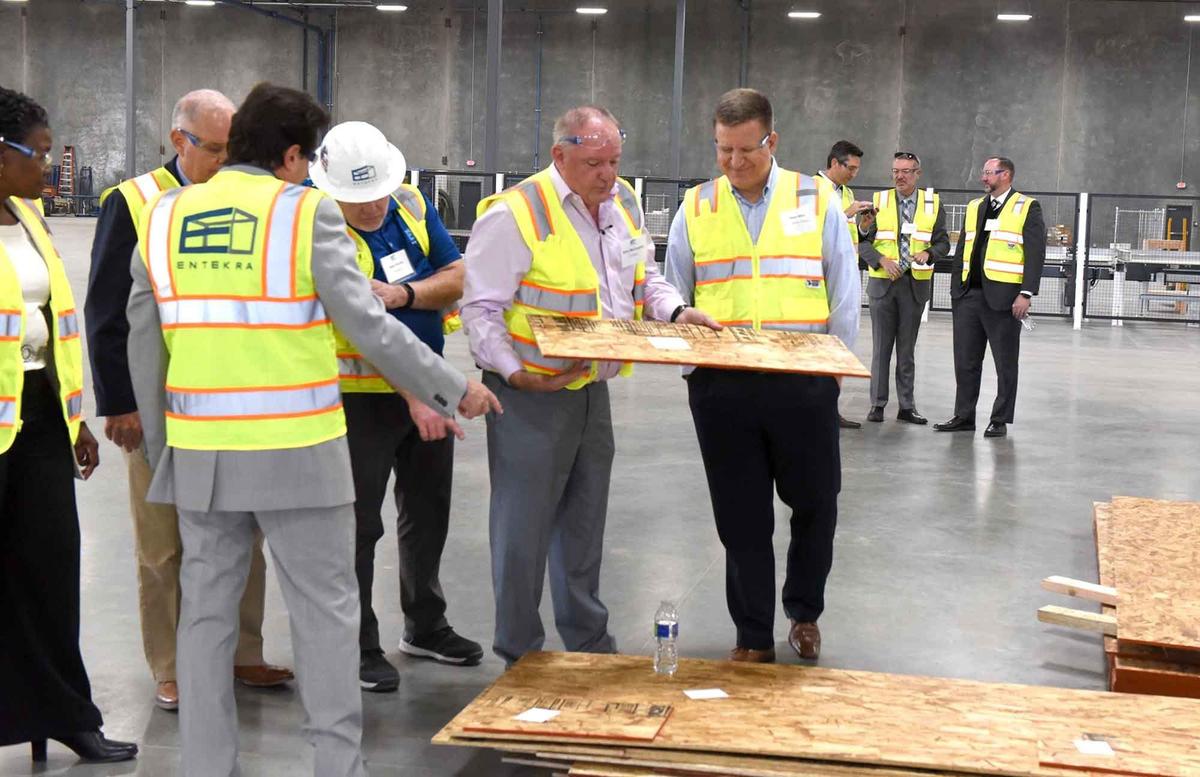 Entekra CEO Gerry McCaughey (center left) shows David White, the CEO of Opportunity Stanislaus a sheeting board Monday November 4, 2019 at Entekra in Modesto, Calif.