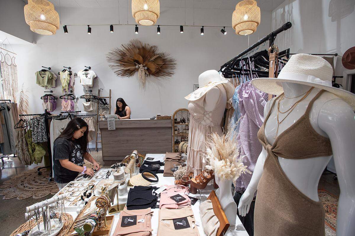 Zyanya Gil, 10, left, helps out at her mother’s new boutique, Zyanya Boutique on 13th Street in Modesto, Calif., on Thursday, July 8, 2021. Retail sale associate Mikayla Bravo works on the computer at the counter.