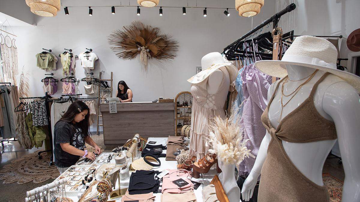 Zyanya Gil, 10, left, helps out at her mother’s new boutique, Zyanya Boutique on 13th Street in Modesto, Calif., on Thursday, July 8, 2021. Retail sale associate Mikayla Bravo works on the computer at the counter.