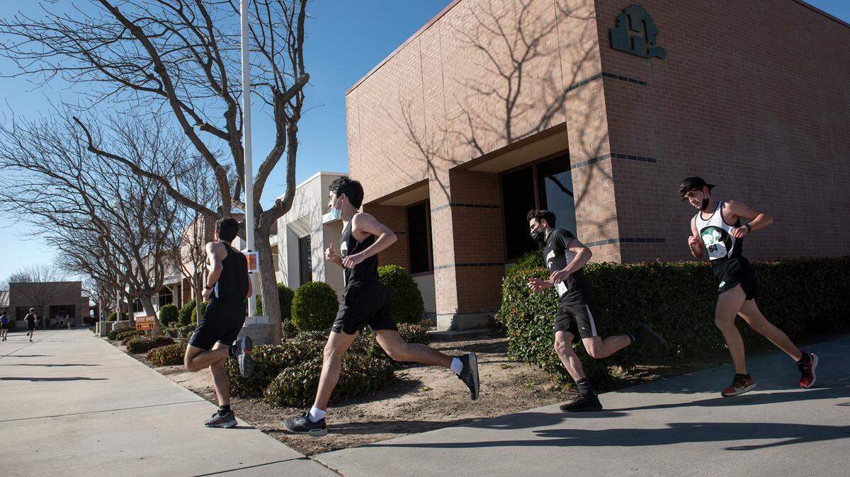Varsity boys pass classrooms on the Pitman campus during the Central California Athletic League cross country meet at Pitman High School in Turlock, Calif., on Tuesday, Feb. 24, 2021.