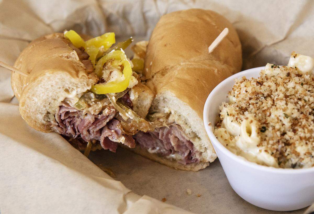 Filthy Fix sandwich (Cured pork, mayo, cream cheese, grilled sweet onions and bell peppers, hot waxed peppers, on Bolillo roll) with a side of mac& cheese at Food Fix Butcher & Baker restaurant in Modesto, Calif., Thursday, Aug. 22, 2019.