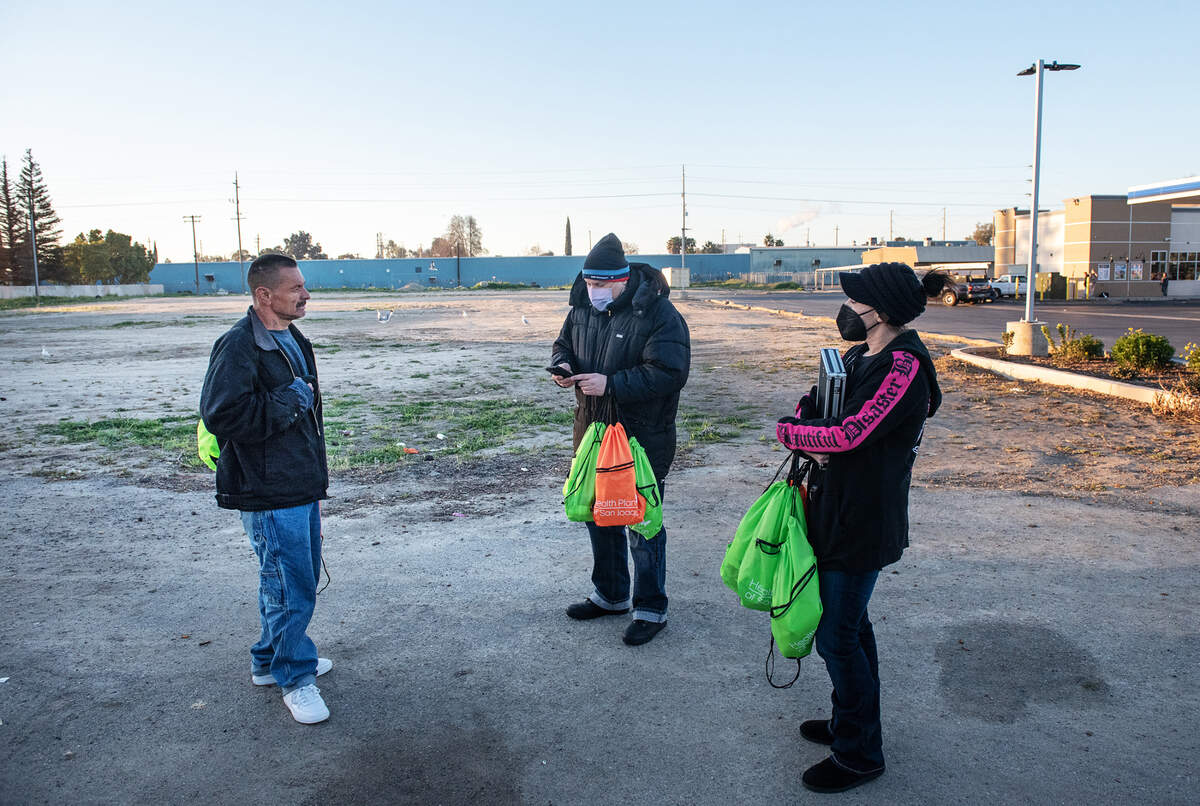 Volunteers Emily Owen, right, and Damien Martinez talk with Richard Dominguez during the annual count of Stanislaus County’s homeless in Modesto, Calif., on Thursday, Feb. 24, 2022. The U.S. Department of Housing and Urban Development requires local communities to conduct the annual point-in-time count to receive homeless funding.