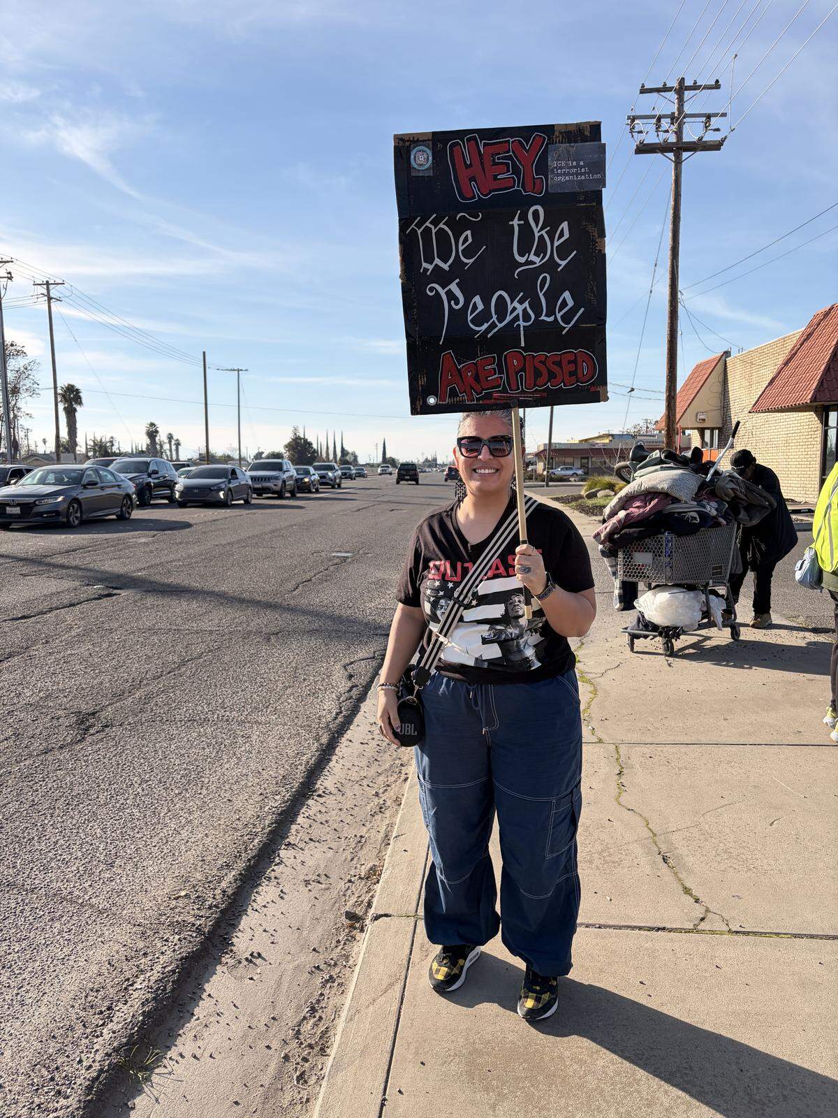 Angelica Foreman, 42, of Modesto, holds up a sign at the anti-ICE rally at the intersection of Hatch and Crows Landing roads in south Modesto on Saturday, Jan. 10, 2026.