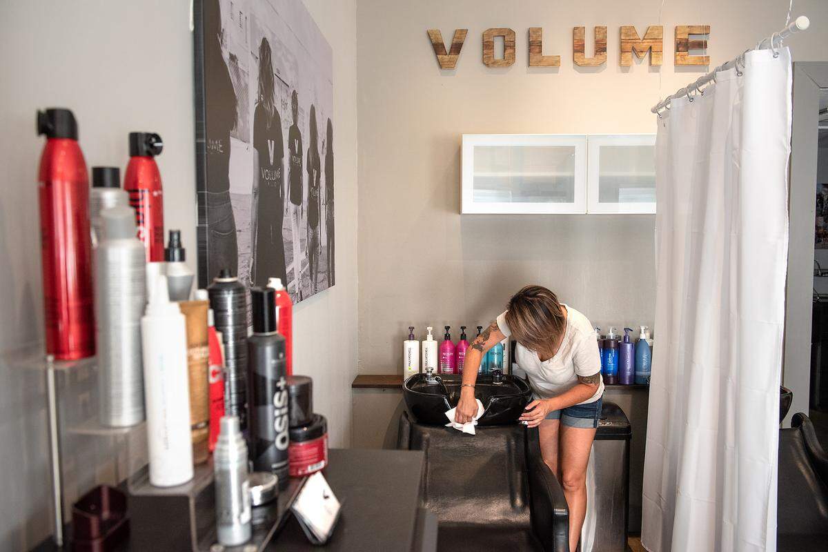 Volume Salon owner Cheryl Avina cleans a hair washing station in preparation for re-opening on Monday. Photographed in Modesto, Calif., on Friday August 28, 2020.