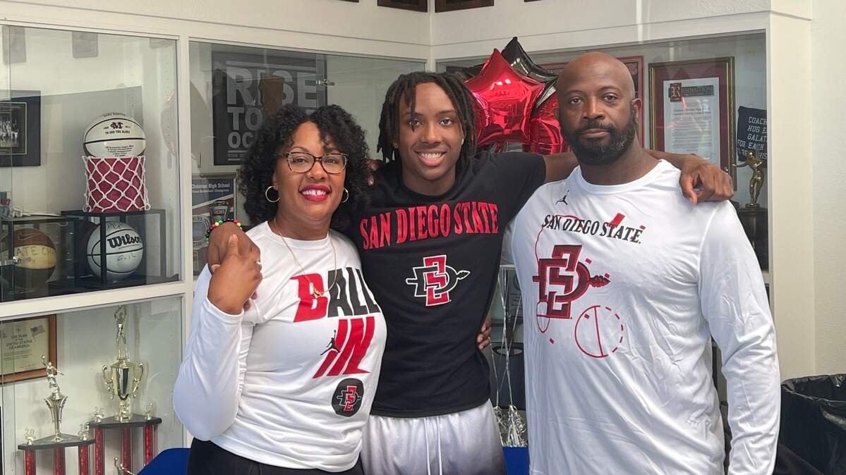 Modesto Christian guard BJ Davis takes a picture with his parents, Sunjia Davis and Bryant Davis Sr. at his commitment ceremony in the Modesto Christian gym on Friday, September 23, 2022.