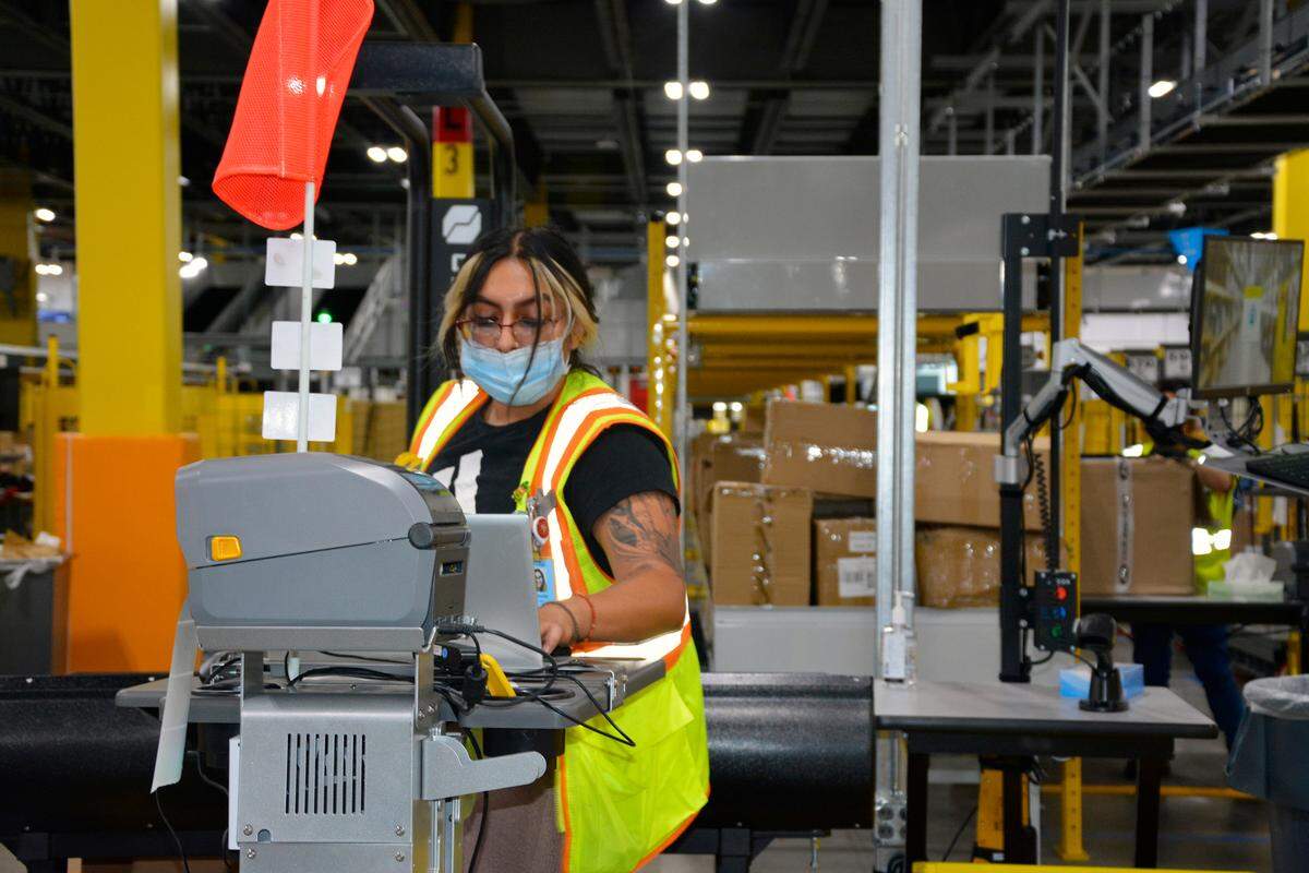 A worker sorts items inside the new Amazon fulfillment center in Turlock, Calif. Oct. 20, 2022.