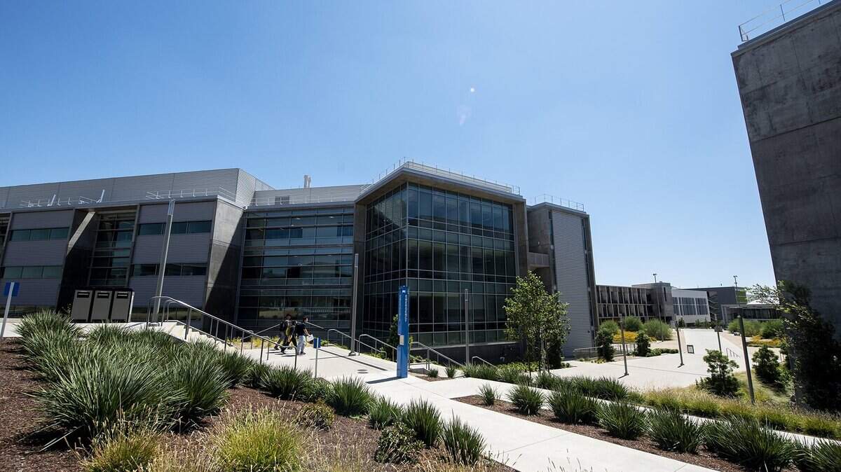People walk down the stairs between the Biomedical Sciences and Physics Building, left, and the Sustainability Research and Engineering Building, right, on the University of California, Merced campus in Merced, Calif., on Thursday, Aug. 6, 2020.