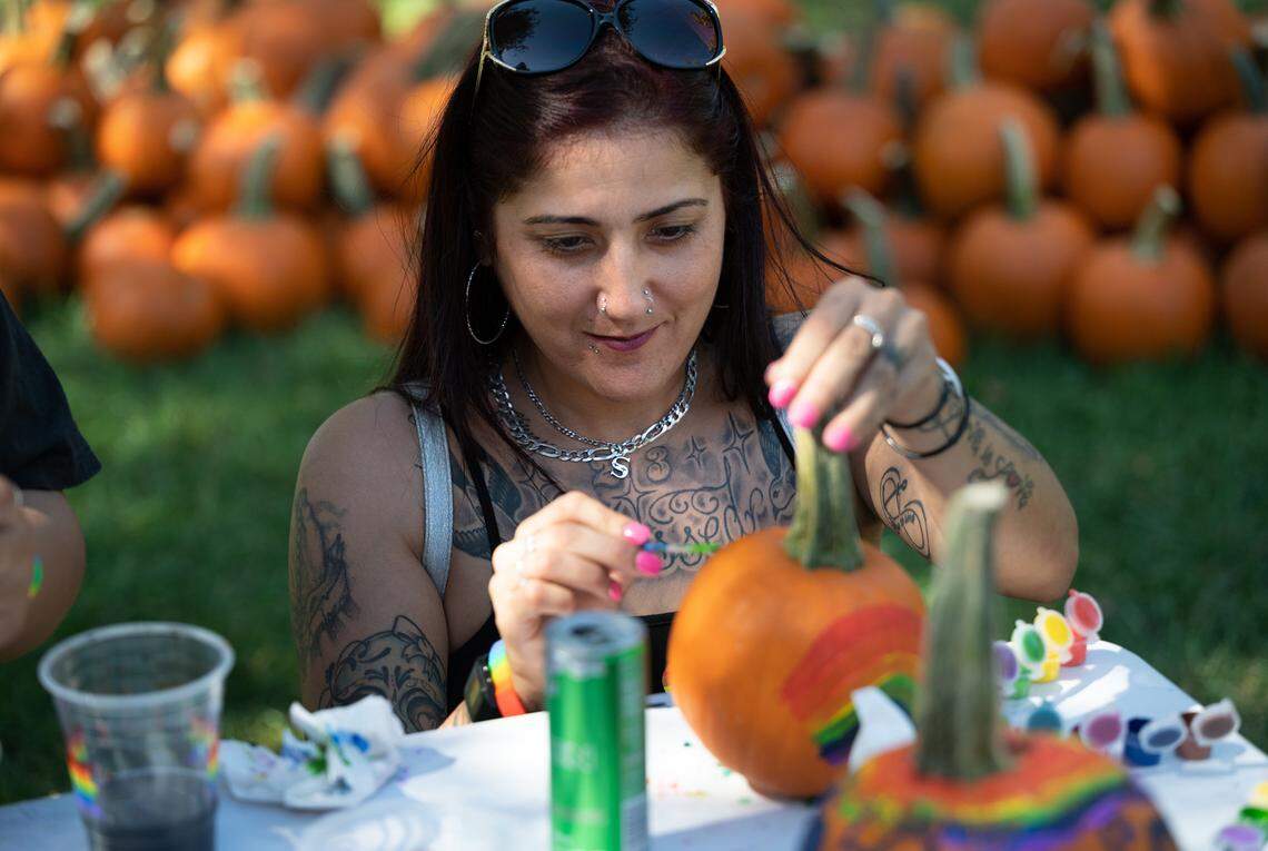 Sylvia Cuadras decorates a pumpkin during the MoPride festival at Graceada Park in Modesto, Calif., Saturday, Oct. 1, 2022.