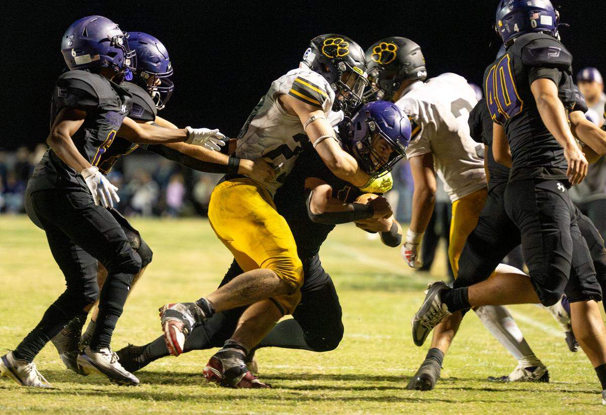Hughson’s Titus Beers wraps up Escalon quarterback Logan Huebner during the Trans-Valley League game at Escalon High School on Friday, Oct. 3, 2025.