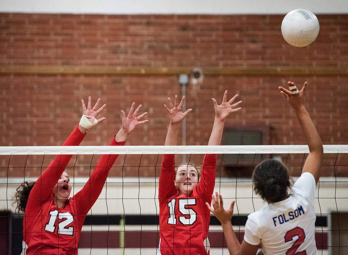 Folsom’s Karmin Brown (2) floats the ball past Modesto’s Shelby Benz (12) and Lauren Thompson (13) during the Sac Joaquin Section playoff game at Modesto high School in Modesto, Ca., on Tuesday, Oct. 23, 2018.