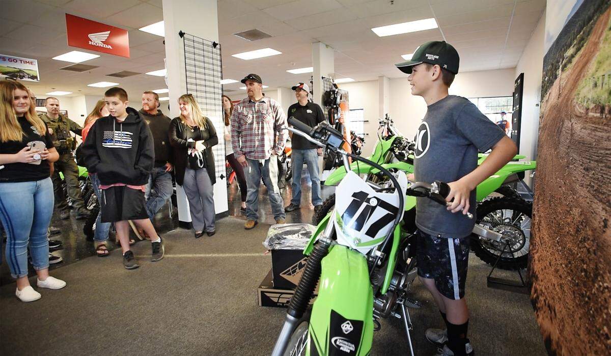 Chase Garner, 12, son of late Stanislaus SheriffÕs Deputy Jason Garner was surprised with a new motorized dirt bike. Local law enforcement officers, businesses and community members raised funds for the off-road motorcycle. Photographed at Honda Kawasaki KTM in Modesto, Calif., Saturday, Nov. 16, 2019.
