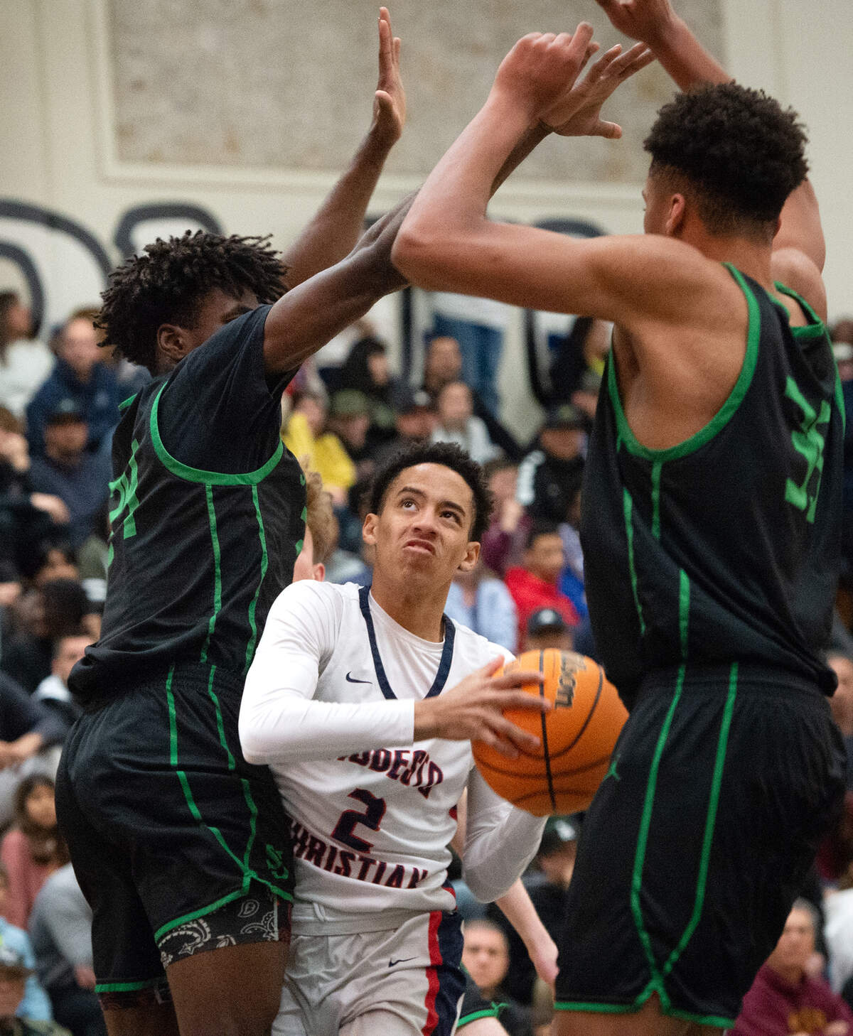 Modesto Christian’s Rashod Cotton looks to shoot the ball as St. Joseph defenders Tounde Yessoufou , left, and Caedin Hamilton during the NorCal Open Division championship game at Modesto Junior College in Modesto, Calif., Tuesday, March 7, 2023. St. Joseph won the game 72-58.