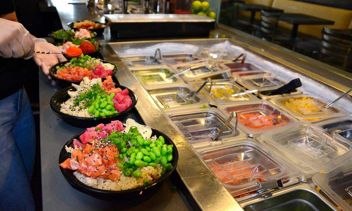 Poke Mi! employee Natalie Monarrez makes poke bowls at the new restaurant in the McHenry Village in Modesto, Calif.