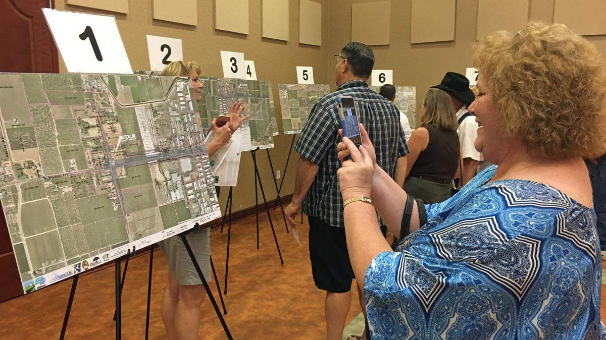 Hylee Griffith of Oakdale takes a photo of a map at an open house meeting for the future North County Corridor at the Gene Bianchi Community Center, Oakdale, Sept. 7, 2017.