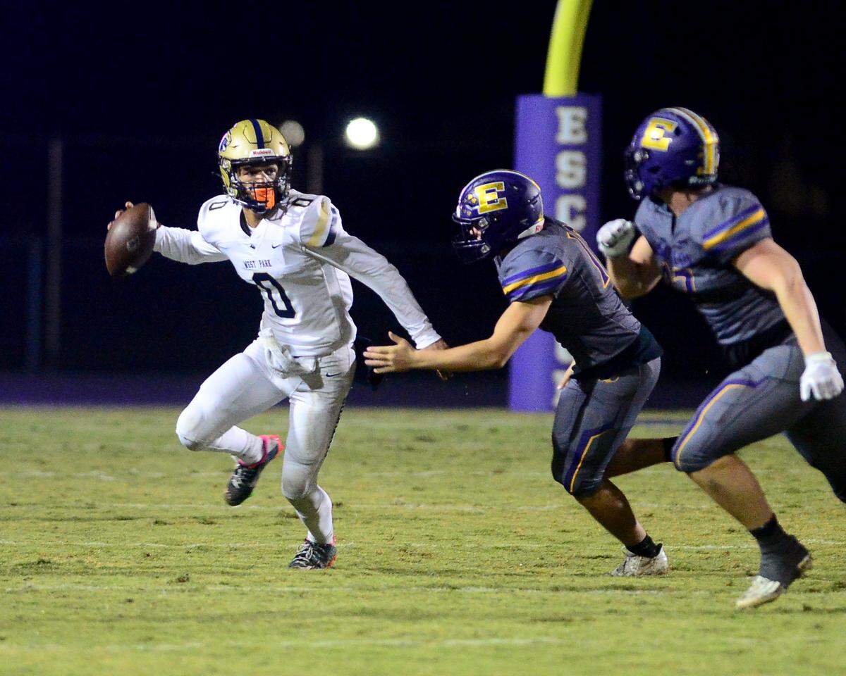 West Park quarterback Jaden Jackson (0) scrambles away from Escalon defenders during a 2023 CIF San Joaquin Section Division IV football game between Escalon and West Park at Escalon High School in Escalon, California, on Nov. 17, 2023. Escalon won the game 48-28.