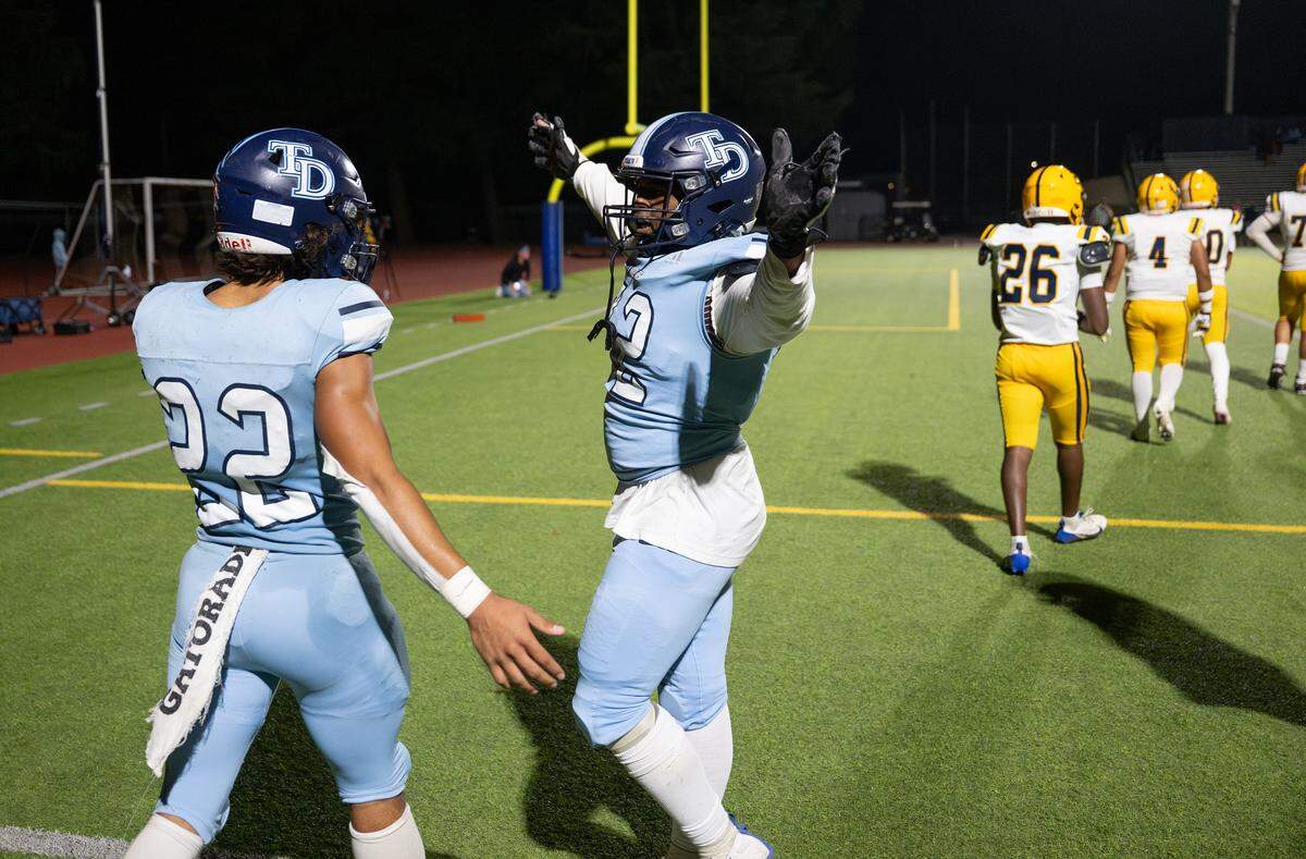 Downey’s Calvin Davis celebrates a touchdown with Elias Haynes in the Central California Athletic League game at Downey High School in Modesto on  Friday, Oct. 24, 2025.