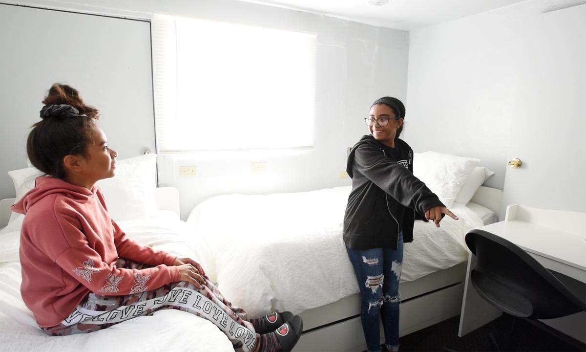 Sisters Olivia Vargas, 10, and Ahli, 13, right, react to seeing their bedroom makeover in Modesto, Calif., on Friday, June 3, 2022. Modesto Police and other local law enforcement members remodeled six rooms for nine children in Modesto and Empire through 10K with a Cop and the Healthy Room Project.