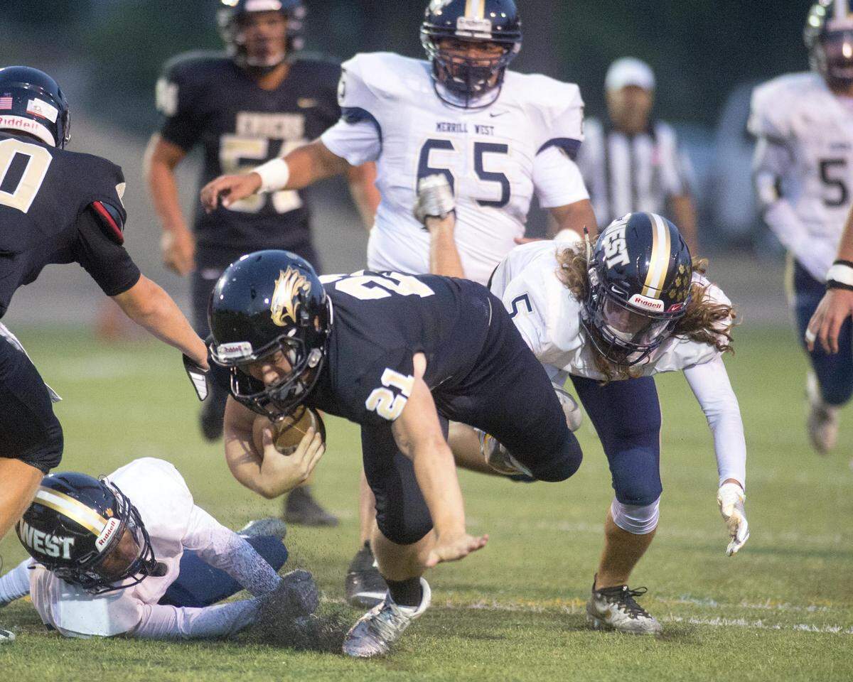 Enochs running back John Holbrook gets taken down by multiple West defenders during a game between Enochs and Tracy West in Modesto at Downey High School on August 24, 2017.