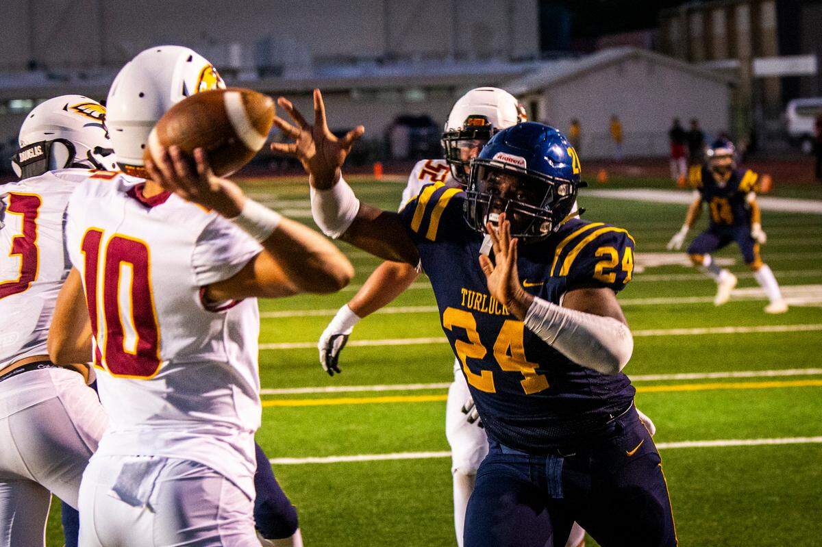 Turlock High defender Tarell Johnson (24) puts pressure on Clovis West quarterback Tyler Franklin (10) on Friday night.