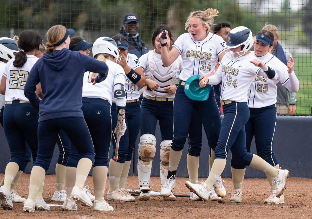 Central Catholic team members celebrate as Emori Machado arrives at home plate after a home run during the Valley Oak League game with Manteca at Central Catholic High School in Modesto, Calif., on Monday, March 28, 2022. Central Catholic won the game 1-0.