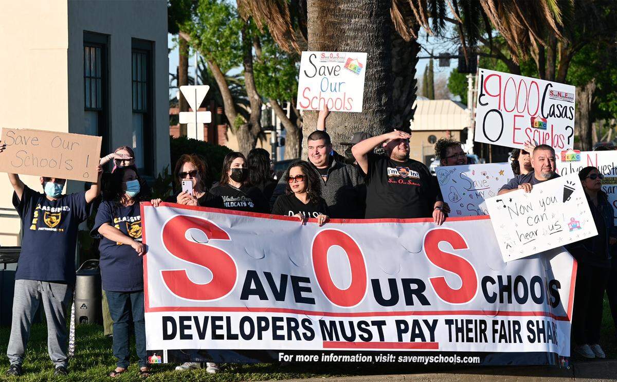 Teachers, students and parents rally outside Patterson City Hall in Patterson, Calif., on Tuesday, April 5, 2022. Educators organized the “Save Our Schools Rally” through the Patterson Education Advocacy Committee to highlight their concern that new residential developments will cause overcrowded schools and an unfair tax burden on local residents.