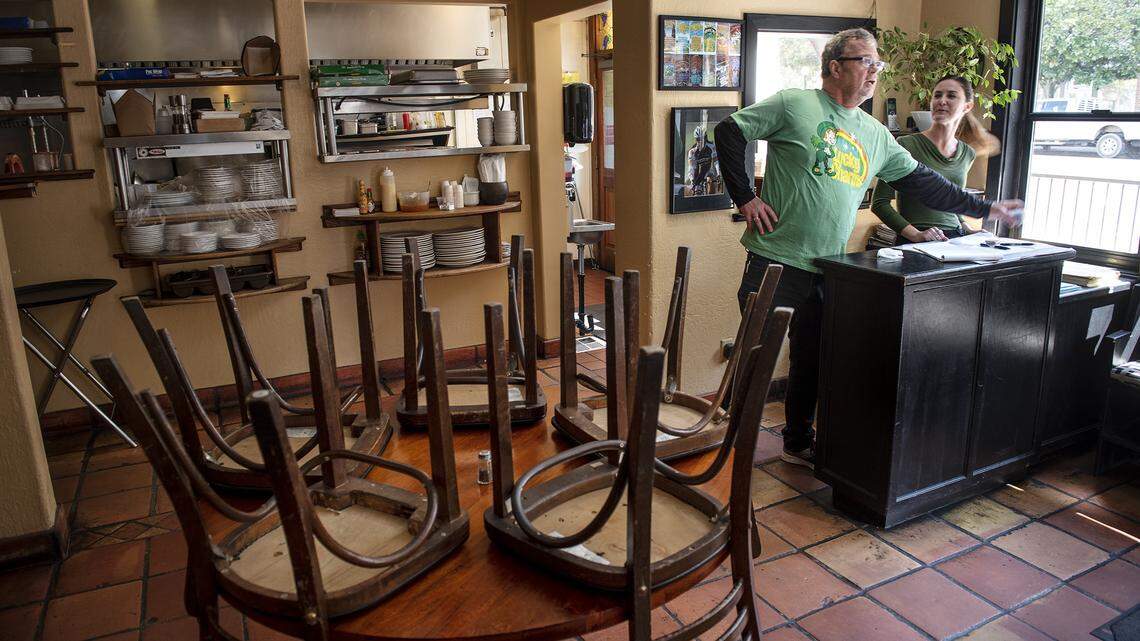 Harvest Moon restaurant owner Mark Smallwood and server Lindsey Gildea, right, handle a small selection of takeout orders at in Modesto, Calif., on Tuesday, March 17, 2020. Smallwood closed his dining room on Tuesday to comply with governor Gavin Newsom’s request that restaurants limit themselves to delivery or takeout.