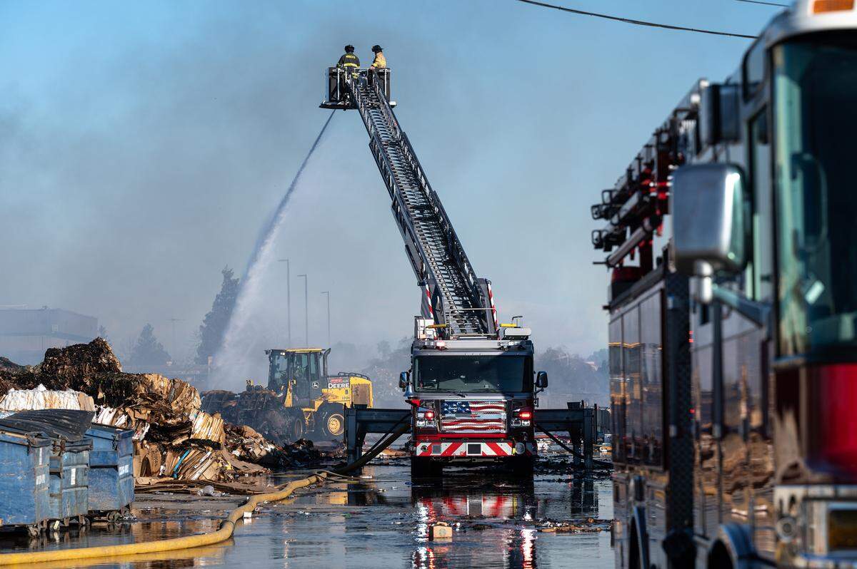 Ceres and Modesto firefighters mop up after a fire at American Recycling on Morgan Road in Modesto, Calif., on Tuesday, Feb. 15, 2022.