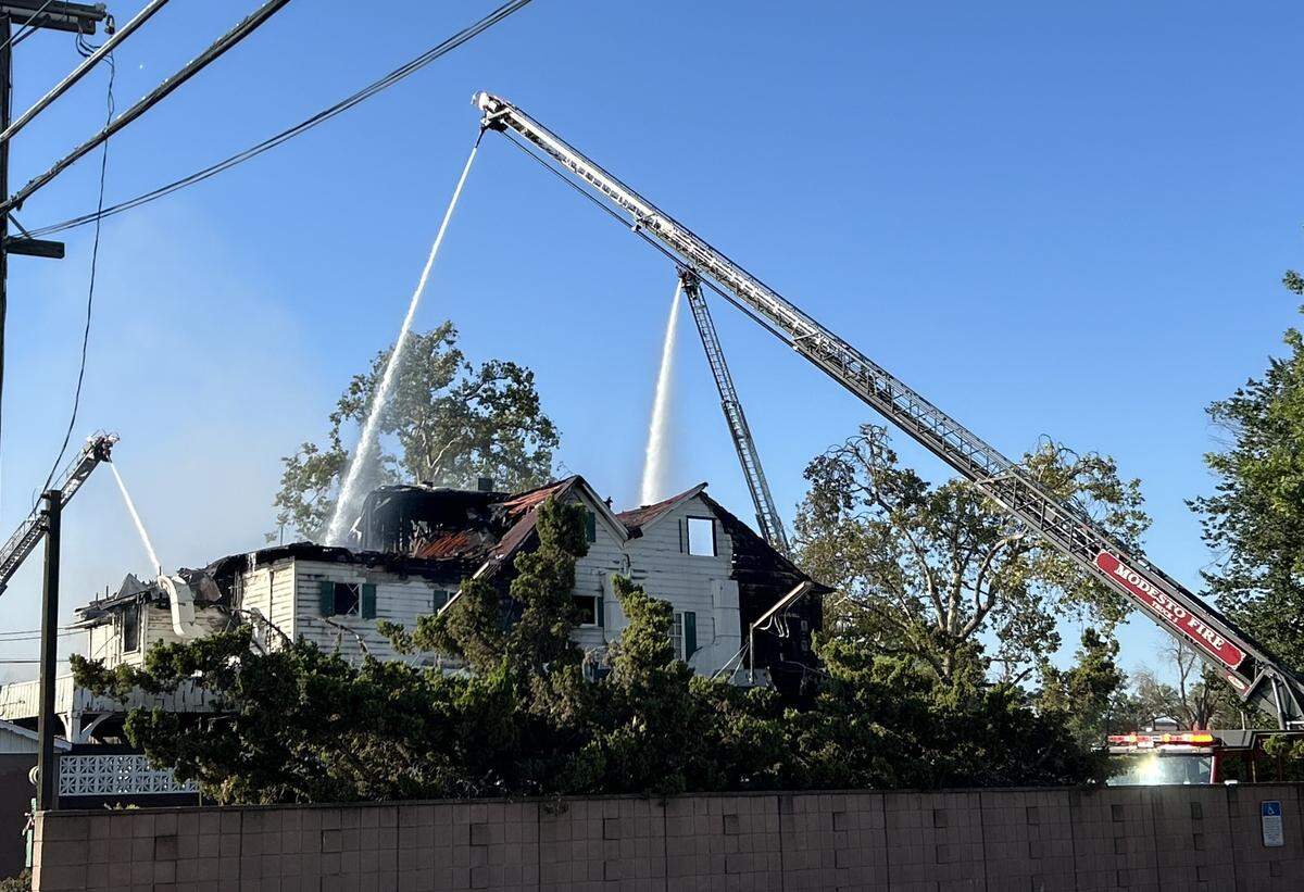 Firefighters work to extinguish the blaze at the former Franklin and Downs Funeral Homes building at 12th and G streets in downtown Modesto on Tuesday morning, July 16, 2024.