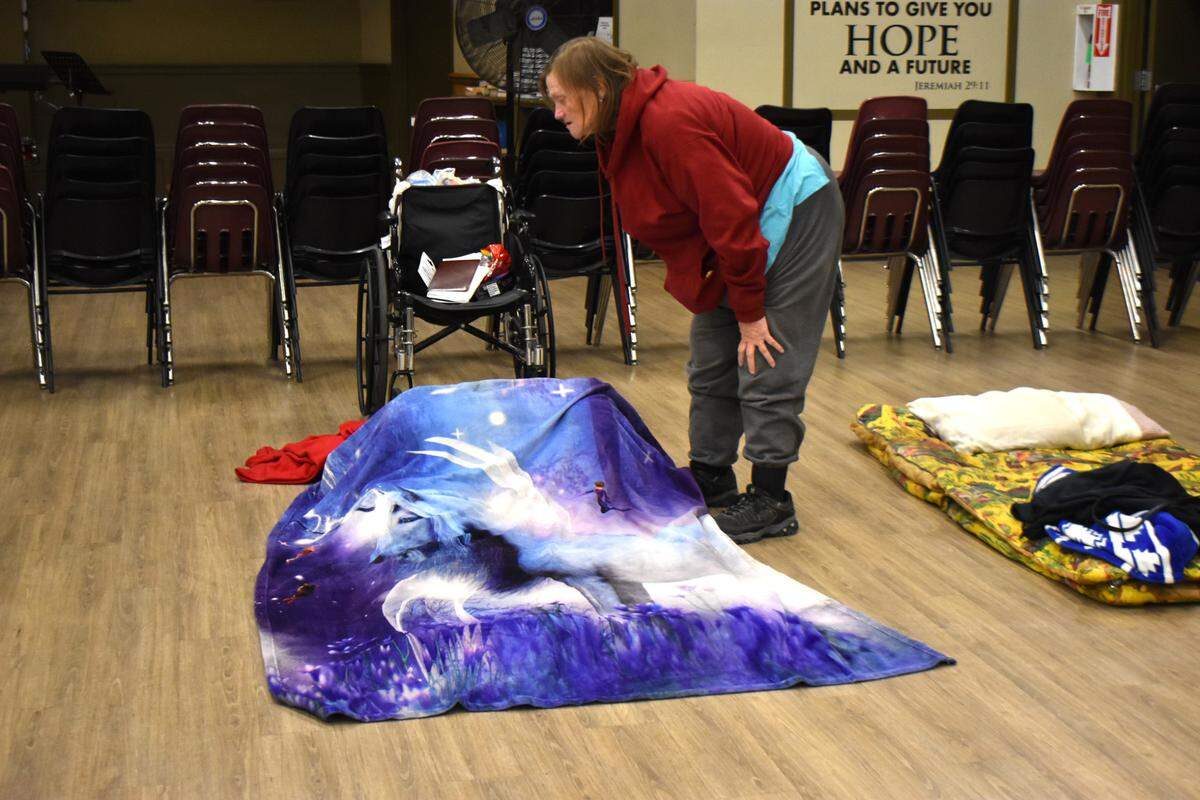 Peggy Merrell prepares her sleeping spot at the Modesto Gospel Mission on Yosemite Boulevard on Thursday night, Nov. 9, 2023.
