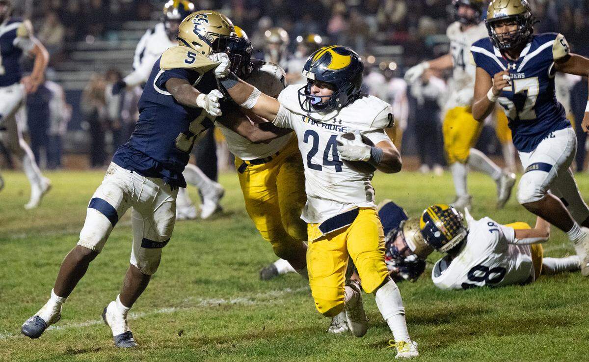 Oak Ridge’s Erick Orme Jr. fights off Carter Meeks on a run during the Sac-Joaquin Section Division I semifinal playoff game with Central Catholic at Central Catholic High School in Modesto, Calif., Friday Nov. 17, 2023. Oak Ridge won the game 31-14.