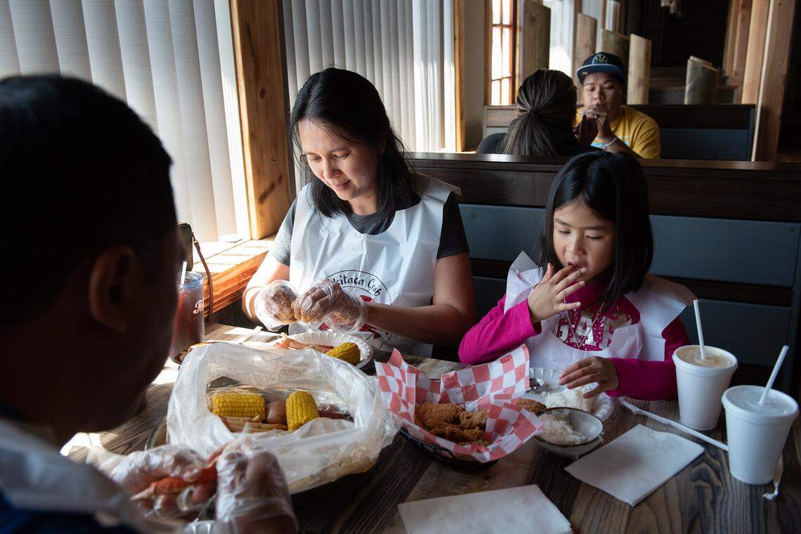 Kristine and Jack Huerto eat lunch at Akitaca Crab seafood restaurant with their daughter Maria, 5, in Modesto, Calif., on Wednesday, March 16, 2022.