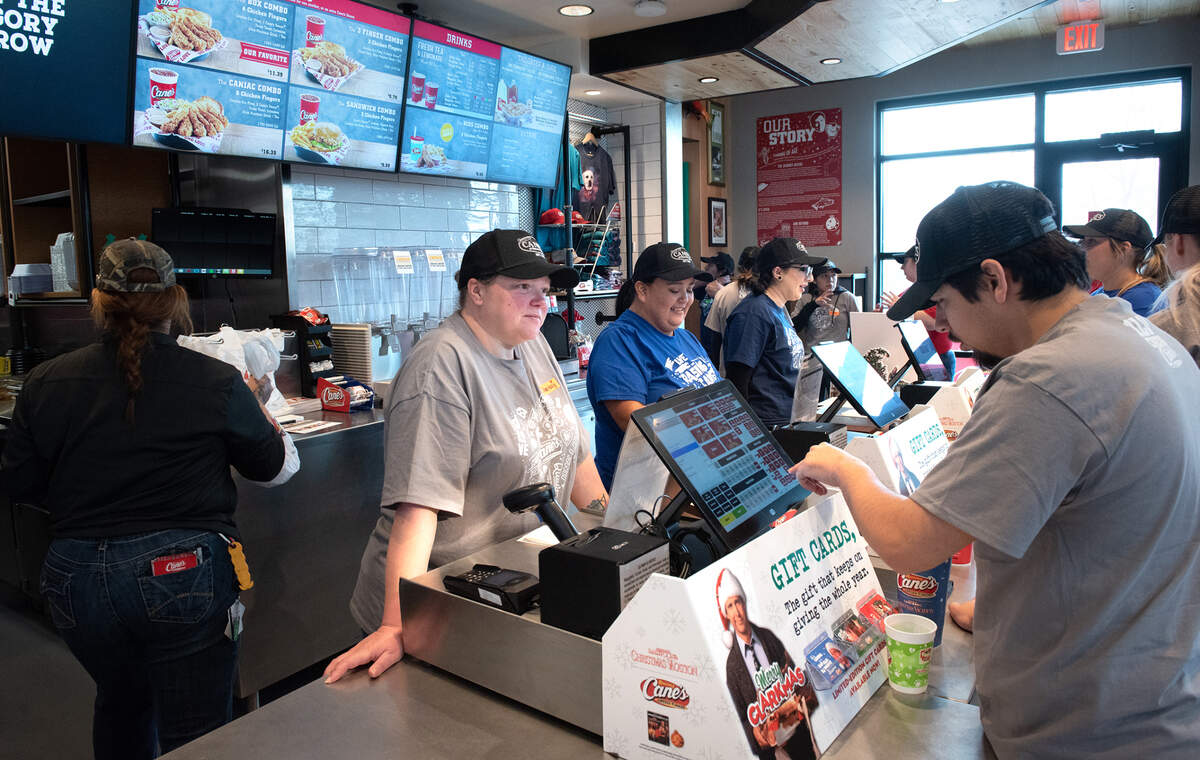 Employees, including Chrissy Silva, middle, and Steven Sweeny, right, participate in training in preparation for Monday’s grand opening at Raising Cane’s Chicken Fingers restaurant in Modesto, Calif., Friday, Dec. 16, 2022.