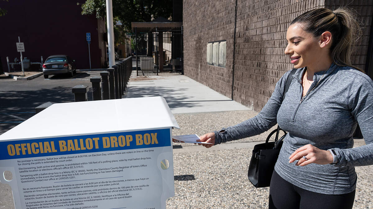 Shanette Meadows of Modesto drops a ballot in 2021 at the Stanislaus County Registrar of Voters office in Modesto, Calif.