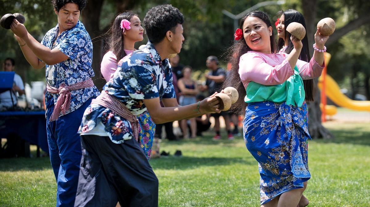 Pholy Meas, right, and Kelvin Lang, left, perform a traditional Cambodian coconut dance with members of the Khmer youth of Modesto during the Family International Festival at the King-Kennedy Memorial Center in Mellis Park in Modesto, Calif., Saturday, August 11, 2018.