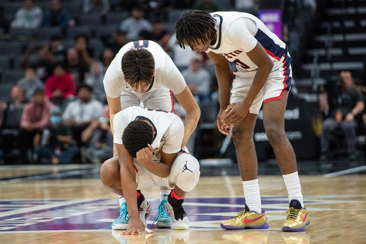 Modesto Christian players Alex Argandar and BJ Davis pick up teammate Jamari Phillips in the final minutes of the boys Open Division CIF State Basketball Championship game with Centennial at Golden 1 Center in Sacramento, Calif., on Saturday, March 12, 2022. Centennial won the game 59-50.