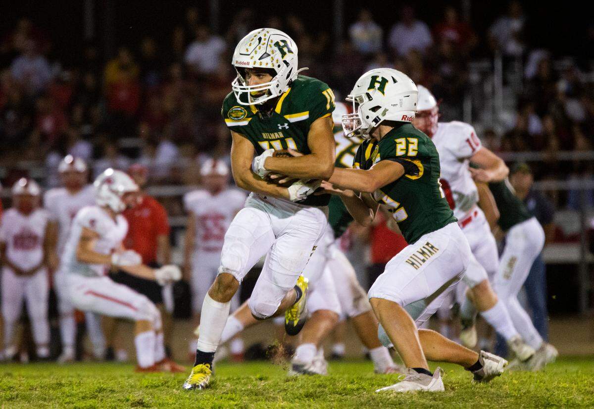 Luis Vargas, 14, of Hilmar High gets the hand off from Caden Bailey, 22, during Friday nights game. Ripon vs Hilmar at Hilmar Sept. 23, 2022.